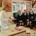 teacher showing students how to bake a recipe