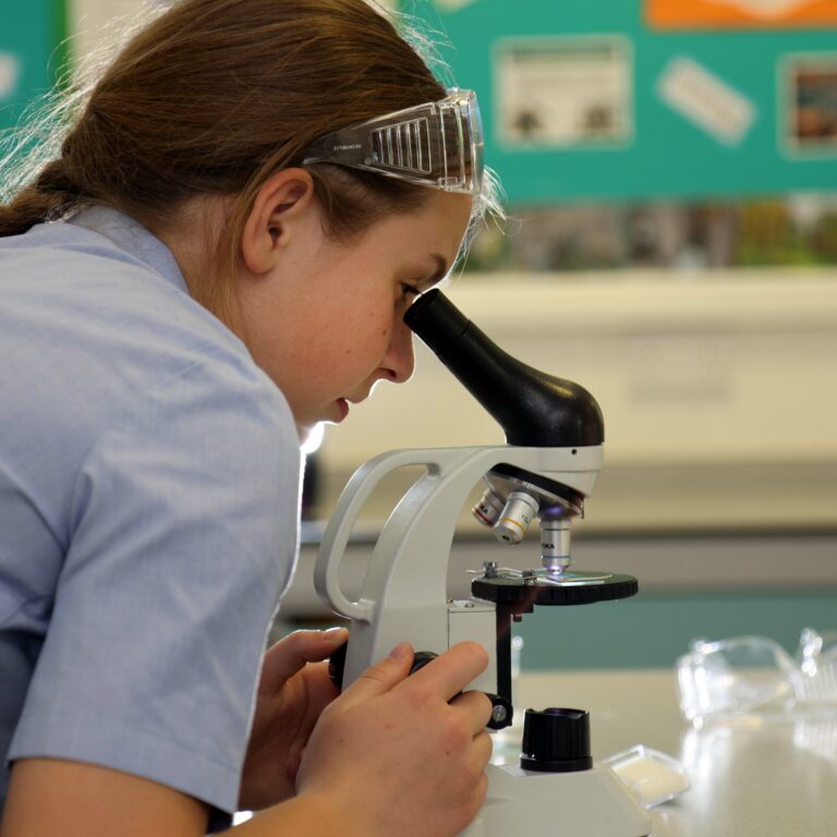 girl looking through microscope