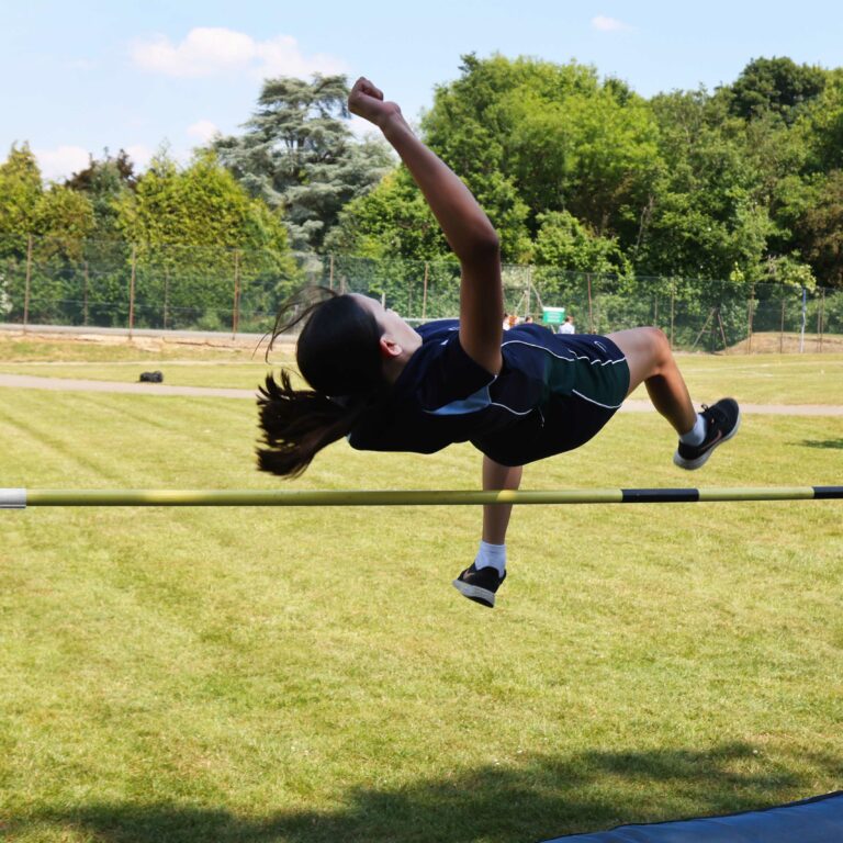 girl vaulting over a pole