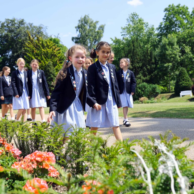 girls walking by some flowers