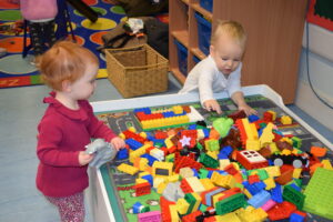 toddlers playing at a table of lego