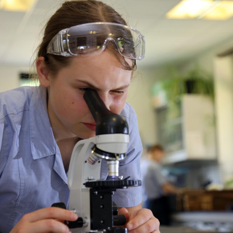 student using a microscope